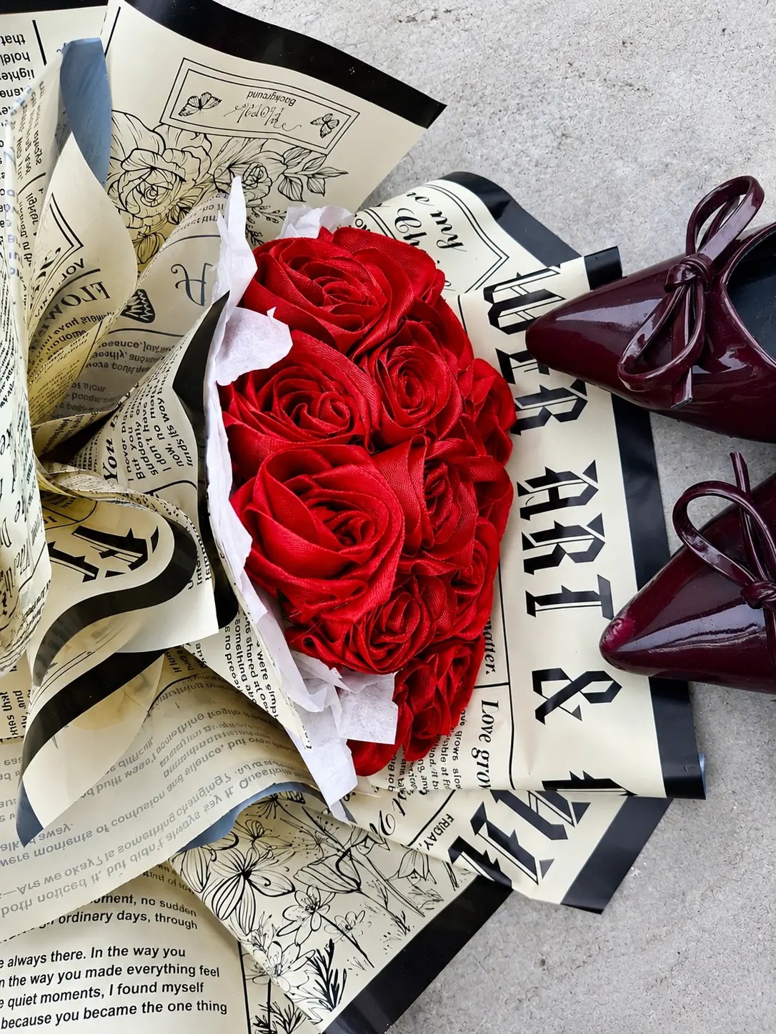 Red satin rose bouquet styled with newspaper wrapping